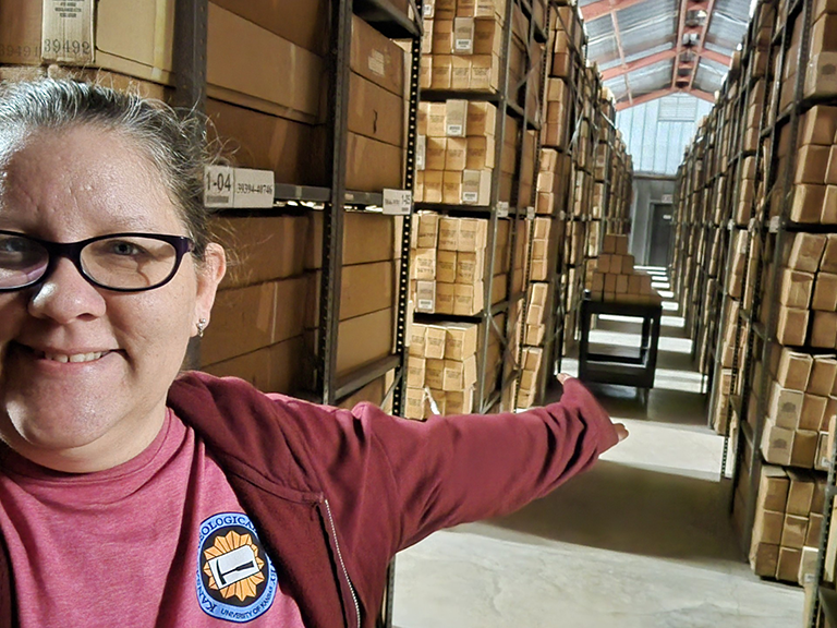Stevens stands in front of rows of samples at the Kansas Geologic Sample Repository in Wichita.
