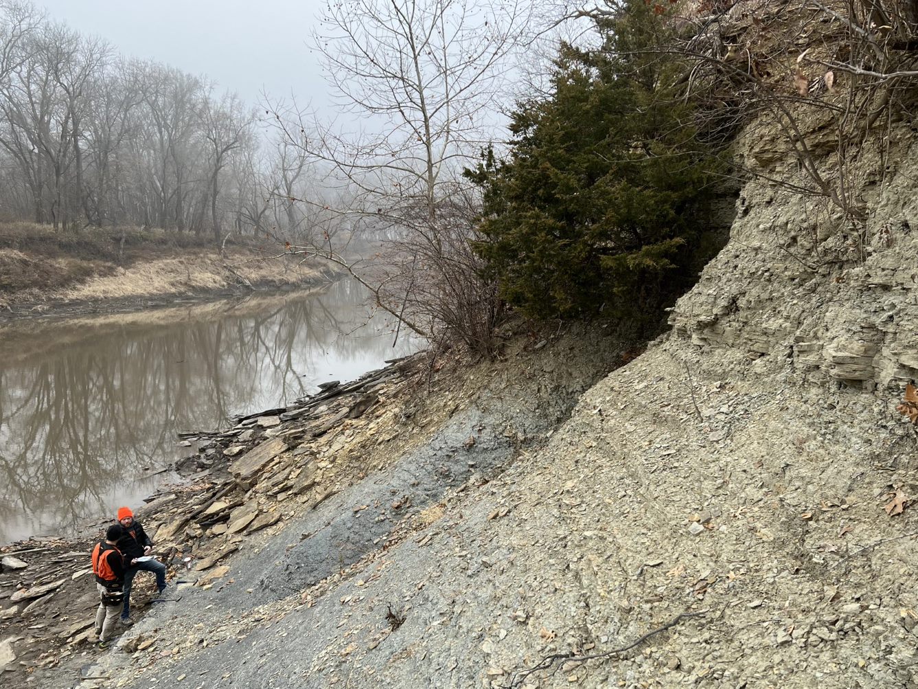 Scientist examining a rock outcrop